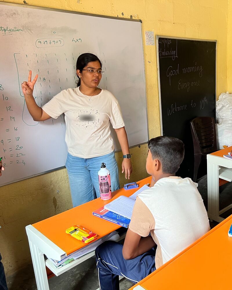 A volunteer teaching multiplication at a maths class